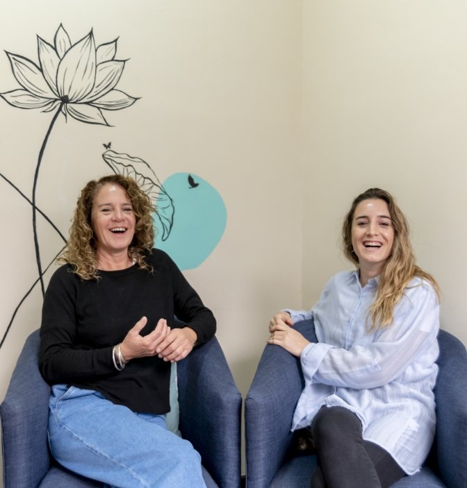 female coworkers smiling while relaxing sitting armchairs break work